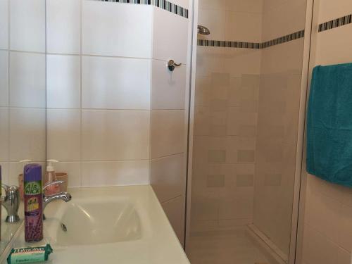 une salle de bain blanche avec une douche et un lavabo dans l'établissement T2 4 pers avec piscine, parking privé, clim en option - Le Barcarès - FR-1-195-95, au Barcarès
