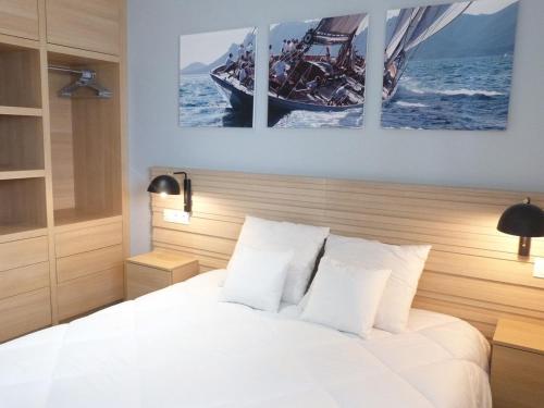 a bedroom with a white bed and a boat at Superbe appartement pour 6 avec balcon, piscine chauffée et accès direct plage à La Tranche - FR-1-194-255 in La Tranche-sur-Mer