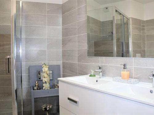 une salle de bain avec un lavabo et une douche avec un miroir dans l'établissement Appartement Neuf 3 Pièces avec Terrasse et Garage, Cagnes-sur-Mer - FR-1-252A-88, à Cagnes-sur-Mer