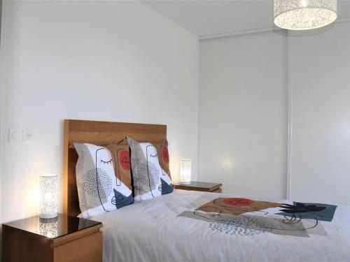 une chambre avec un lit avec des draps blancs et des oreillers dans l'établissement Appartement Neuf 3 Pièces avec Terrasse et Garage, Cagnes-sur-Mer - FR-1-252A-88, à Cagnes-sur-Mer