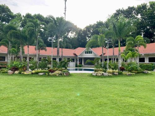 a resort with a yard with a pool and a building at 3 Peaks Resort & Boutique Hotel in Lipa
