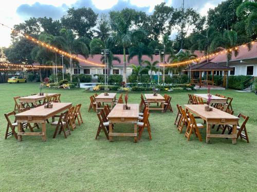 a group of tables and chairs in a field with lights at 3 Peaks Resort & Boutique Hotel in Lipa