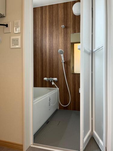 Furano Yayoi-house　 في فورانو: حمام مع دش وحوض استحمام