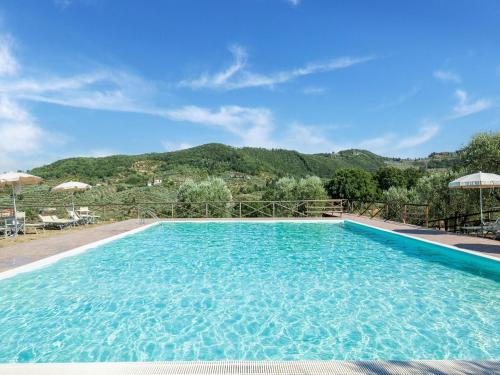 een groot zwembad met een berg op de achtergrond bij Belvilla by OYO La Casa dei Due Olivi in Quarrata