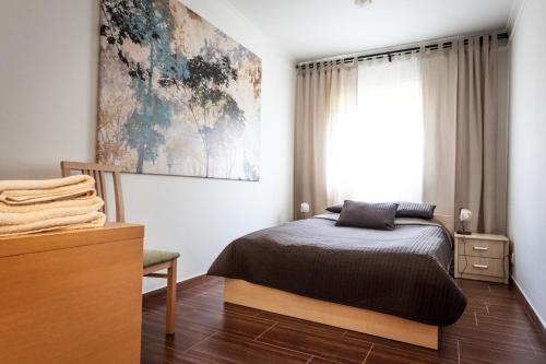 ein Schlafzimmer mit einem Bett und einem großen Fenster in der Unterkunft Apartament Pod Aniołem - 44 in Kazimierz Dolny