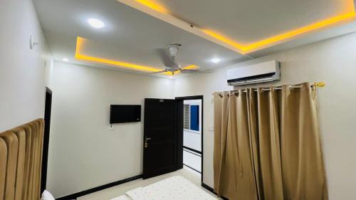 Camera con ventilatore a soffitto e tenda da doccia. di Hotel Double1 a Islamabad