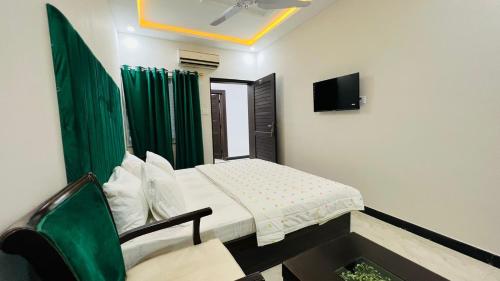 a small bedroom with a bed and a tv at Hotel Double1 in Islamabad