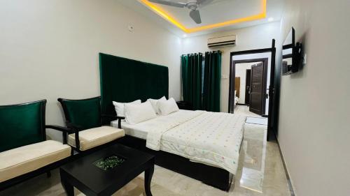 a bedroom with a bed and a couch and a chair at Hotel 11 in Islamabad