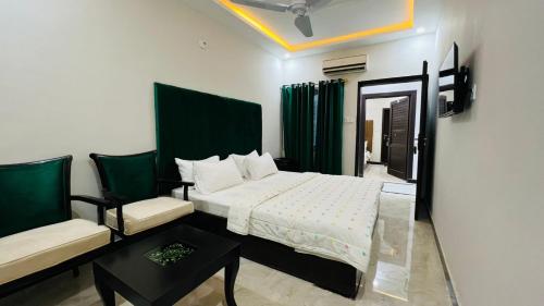 a bedroom with a bed and a couch and a chair at Hotel Double1 in Islamabad