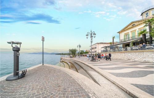 a walkway next to a body of water with buildings at 3 Bedroom Stunning Home In Lazise in Lazise