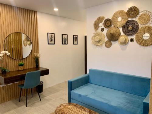 a living room with a blue couch and a mirror at 3 Peaks Resort & Boutique Hotel in Lipa