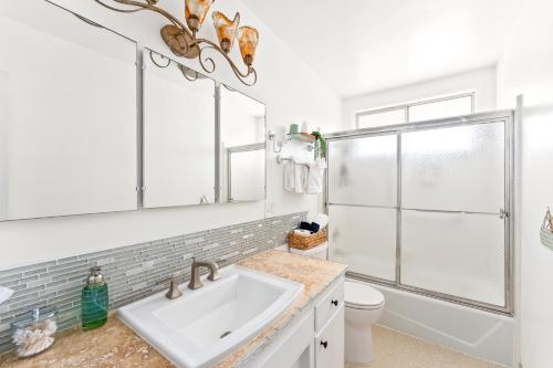 uma casa de banho branca com um lavatório e um chuveiro em *NEW*King Beds*BBQ Grill*Fire-pit*Hammock*workplace em Yucca Valley