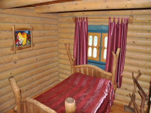 a bedroom with a bed in a log cabin at Gluhoman in Poltava