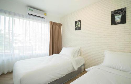 a hotel room with two beds and a window at The Lux Ladprao 10 in Bangkok