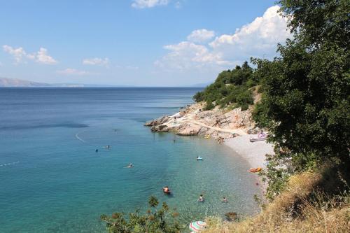 a group of people in the water at a beach at Apartments with a parking space Senj - 14578 in Senj