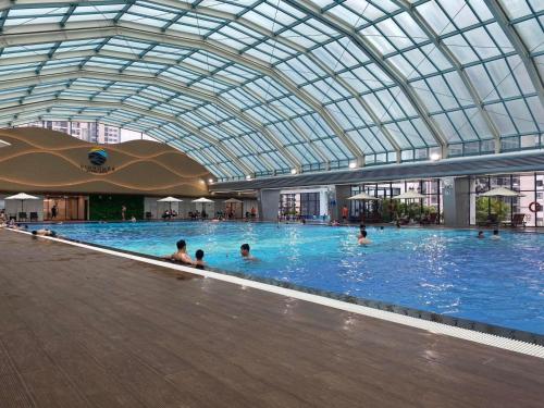 a large indoor swimming pool with people in it at Apartment 1BR-FL12th-R103 Building-Vinhome Ocean Park in Hanoi