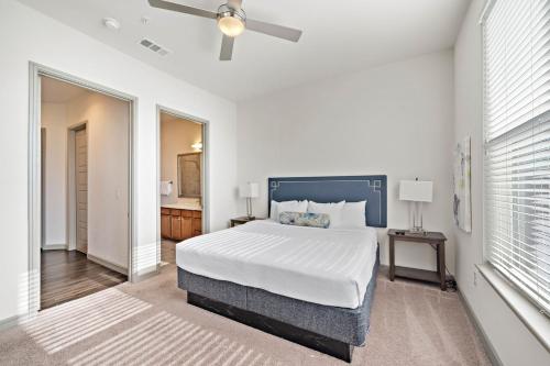 a white bedroom with a bed and a ceiling fan at RENU at Downtown Houston in Houston