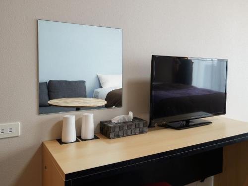 a television sitting on a desk with a mirror at ミチ旅ホテル 読谷 in Yomitan