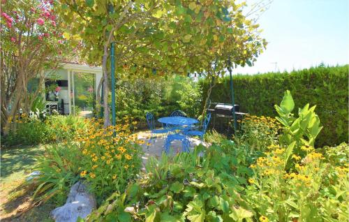 a garden with a blue table and some flowers at Beautiful Home In Donzère With Wifi in Donzère