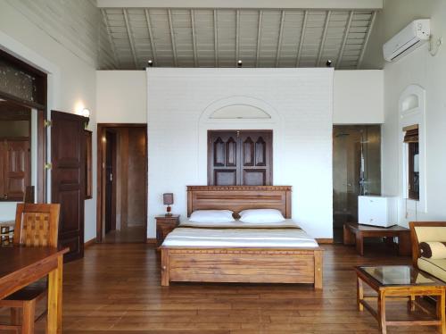 a bedroom with a bed with a wooden headboard at Hotel Leaf on Lagoon in Katunayaka