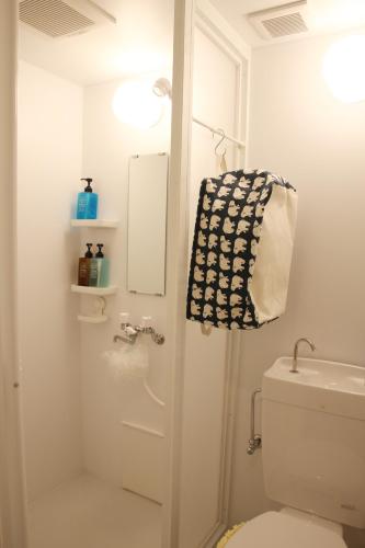 a bathroom with a toilet and a towel on the door at HAMA HILLS Shinjuku in Tokyo