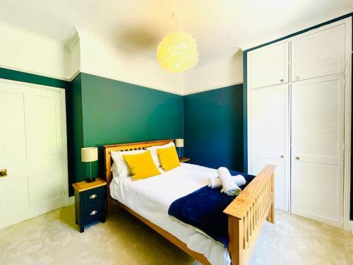 a bedroom with a bed with yellow and blue walls at Pirates Place Ventnor Esplanade Beach and Sea Views in Ventnor