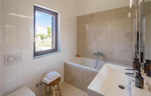 a white bathroom with a tub and a sink at Awesome Apartment In Medulin With Outdoor Swimming Pool in Medulin