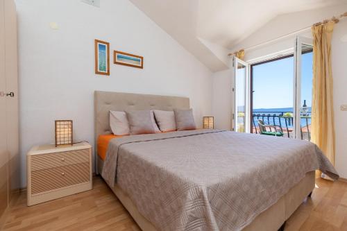 1 dormitorio con cama y ventana grande en Apartments with a parking space Bol, Brac - 2899 en Bol