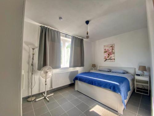 Un dormitorio con una cama azul y una ventana en River House - Luxury house on the border of the Tisza River, en Ároktő