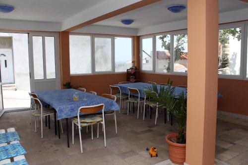 un restaurant avec des tables et des chaises bleues et des fenêtres dans l'établissement Apartment Metajna 527f, à Metajna
