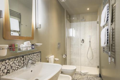 a bathroom with a sink and a toilet and a shower at Hotel Garibaldi Blu - WTB Hotels in Florence