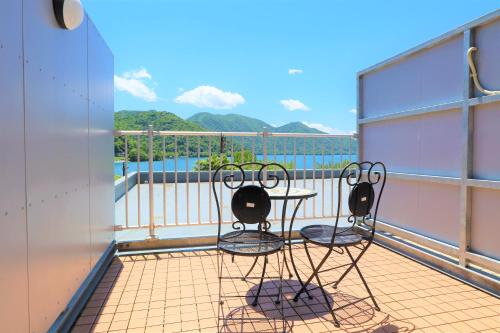 balkon z 2 krzesłami i stołem na statku w obiekcie Hatago Nagomi w mieście Nikko