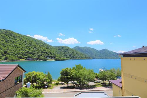 vistas a un lago con montañas en el fondo en Hatago Nagomi en Nikko