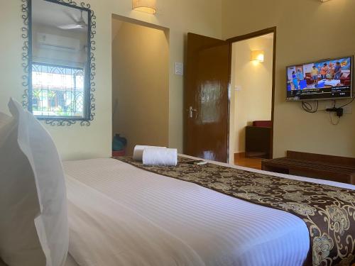 a bedroom with a large bed and a tv at Lifestyle villa in Candolim