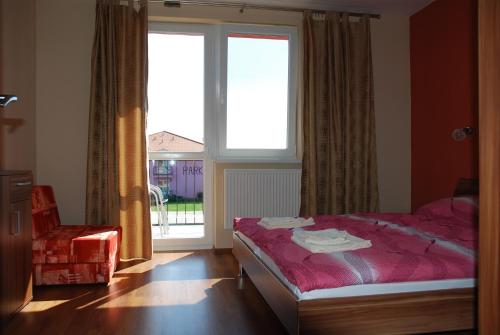 a bedroom with a bed and a large window at Fridrich apartman in Veľký Meder