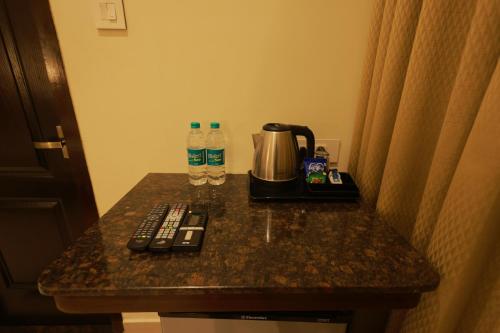 a counter with a coffee maker and water bottles on it at Hotel Comorin Grand in Kanyakumari