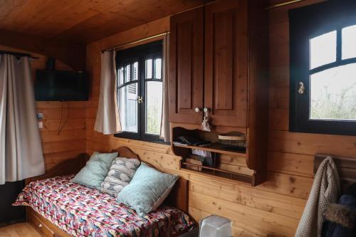 a room with a bed in a wooden cabin at le domaine des drôles de dames in Buding