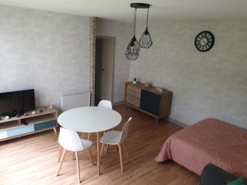 - un salon avec une table, des chaises et un lit dans l'établissement Appartement, Verdun , proche centre ville, à Verdun-sur-Meuse