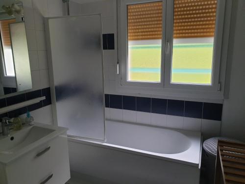 La salle de bains est pourvue d'une baignoire, d'un lavabo et d'une fenêtre. dans l'établissement Appartement, Verdun , proche centre ville, à Verdun-sur-Meuse