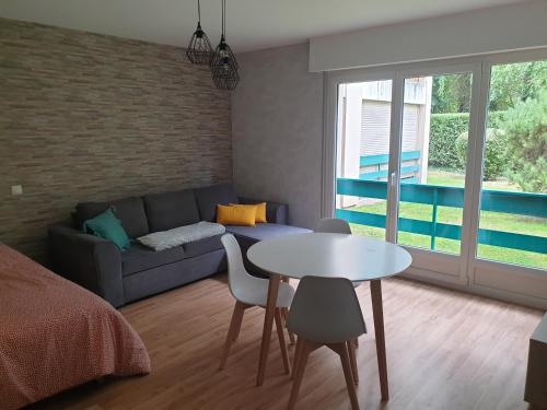 a living room with a couch and a table at Appartement, Verdun , proche centre ville in Verdun-sur-Meuse