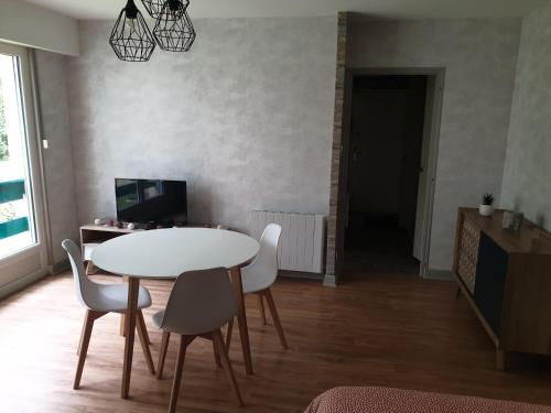 a dining room with a white table and chairs at Appartement, Verdun , proche centre ville in Verdun-sur-Meuse