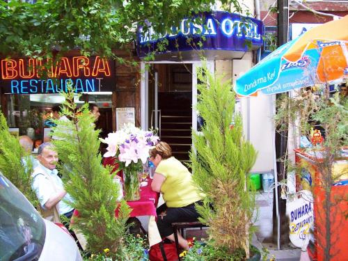 two people sitting at a table in front of a restaurant at Meddusa Hotel in Istanbul