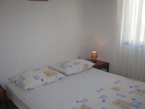 a bedroom with a bed with two pillows on it at Apartments Blanka in Zadar