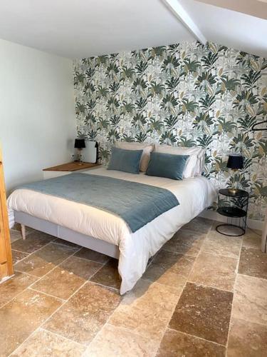 a bedroom with a bed with a floral wallpaper at La Félicité in Boissy-le-Sec