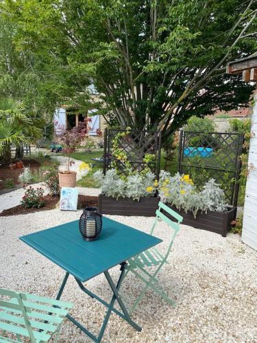a picnic table and two chairs in a yard at La Félicité in Boissy-le-Sec