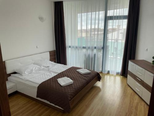 a bedroom with a bed with two towels on it at Spacious and cozy Apartment in complex Del Sol in Primorsko
