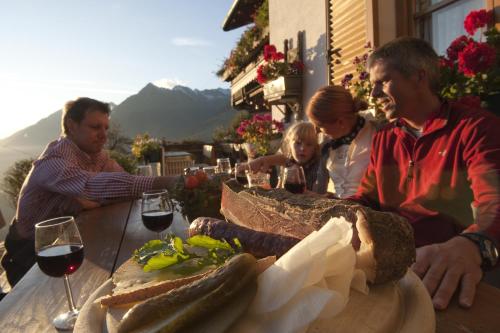 a group of people sitting at a table with a plate of bread at Hotel Garni Lichtenau in Schenna