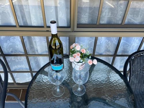 a bottle of wine sitting on a table with two glasses at Highway Motor Inn Taree in Taree