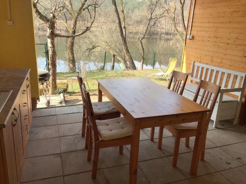 einen Holztisch und Stühle in einer Küche mit Fenster in der Unterkunft Sazava River Cottage with boating experience in Týnec nad Sázavou