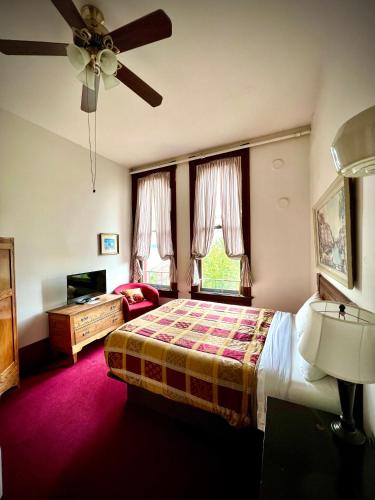 a bedroom with a bed and a ceiling fan at The Monarch Hotel in Port Townsend